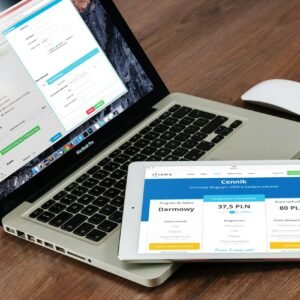 Close-up of a laptop and tablet on a wooden desk, showcasing modern technology.